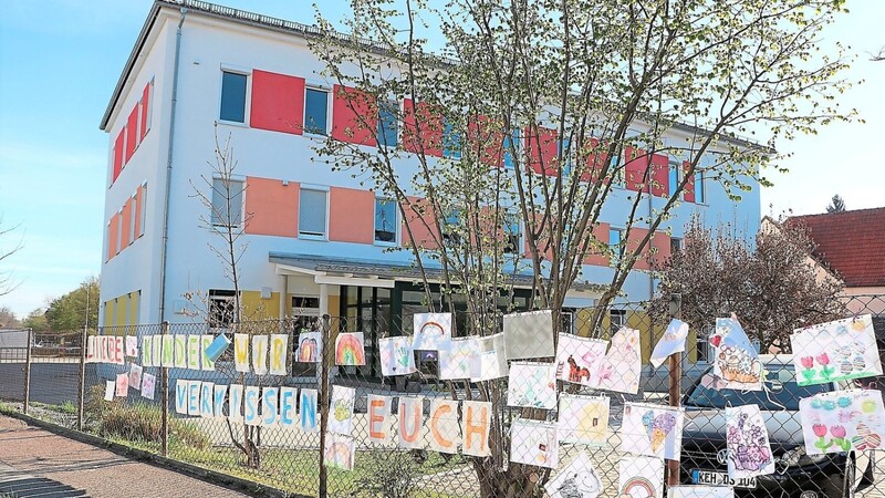 Ein Banner am Zaun des Mainburger Kinderhorts drückt die aktuelle Gefühlslage des Personals aus. Die Kinder haben über Ostern selbstgemalte Bilder dazugehängt.