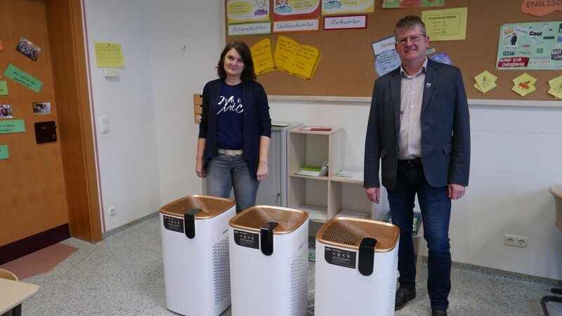 Bürgermeister Heinz Niedermayer und die stellvertretende Schulleiterin Kerstin Baumann-Fischer mit drei Raumlüftungsgeräten