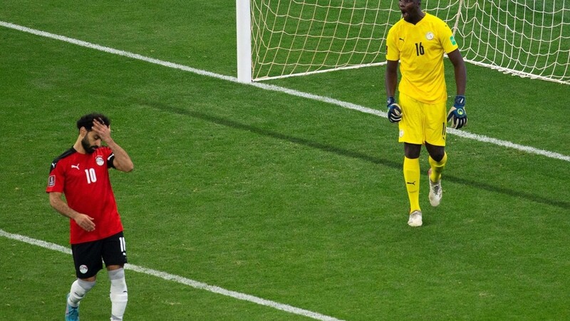 Ägyptens Mohamed Salah (l.) schlägt sich die Hand vor die Stirn, nachdem er seinen Elfmeter gegen Senegals Torhüter Edouard Mendy nicht verwandeln konnte.