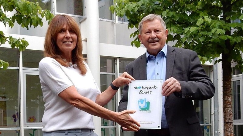 Naturparkvorsitzender Heinrich Schmidt überreicht die Plakette an Rektorin Kerstin Letzel
