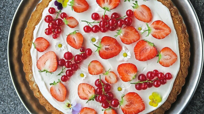 Wer mag, kann den Mandelkuchen mit essbaren Blüten dekorieren.