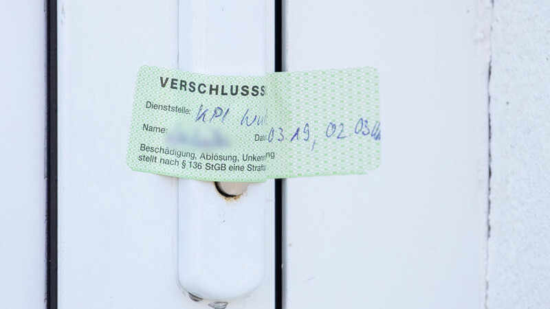 Ein Verschlusssiegel der Würzburger Polizei ist auf die Tür eines Wohnhauses geklebt, das zuvor durchsucht wurde.