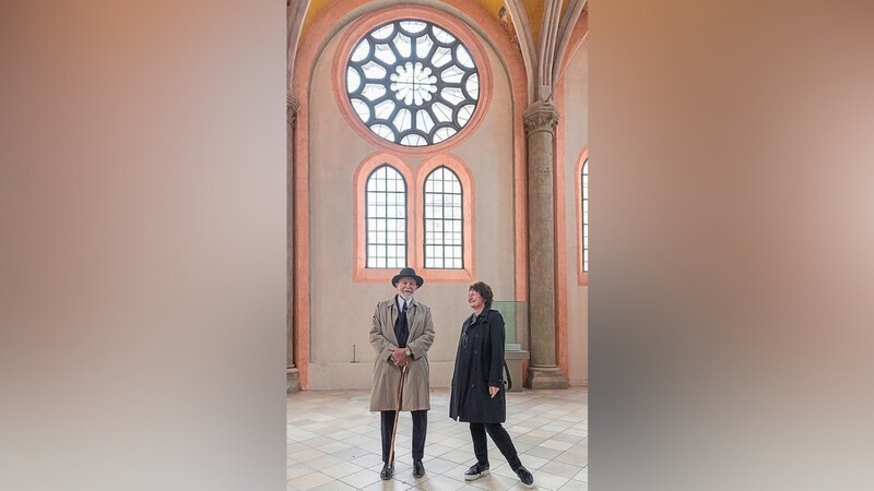 Markus Lüpertz und Maria Baumann vor den Glasfenstern mit jetzt noch Klarglas, die bunt werden sollen. Davor wird der Künstler die Kirche mit einer Ausstellung bereichern.