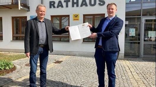 Bürgermeister Johannes Vogl (re.) überreicht die Urkunde für besondere Verdienste um die kommunale Selbstverwaltung an Gemeinderat und zweiten Bürgermeister Rudolf Hohlneicher.
