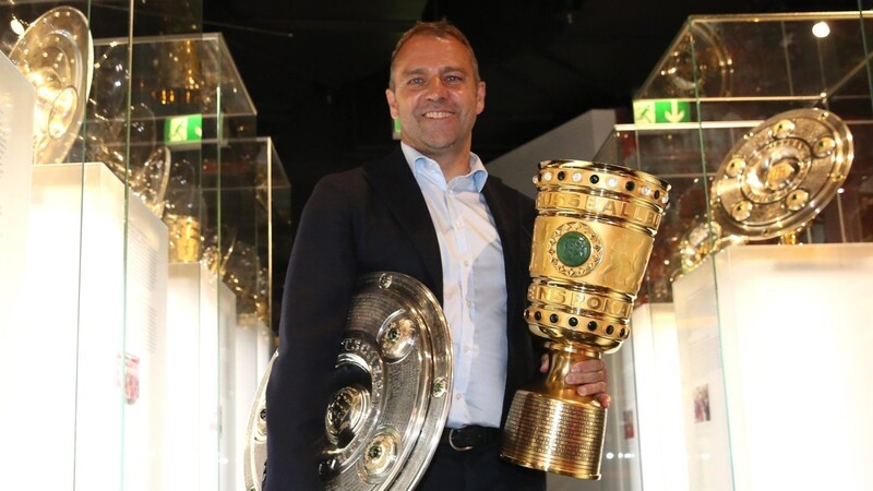 Mann mit Schale und Pokal: Bayern-Trainer Hansi Flick präsentiert die Trophäen im Vereinsmuseum
