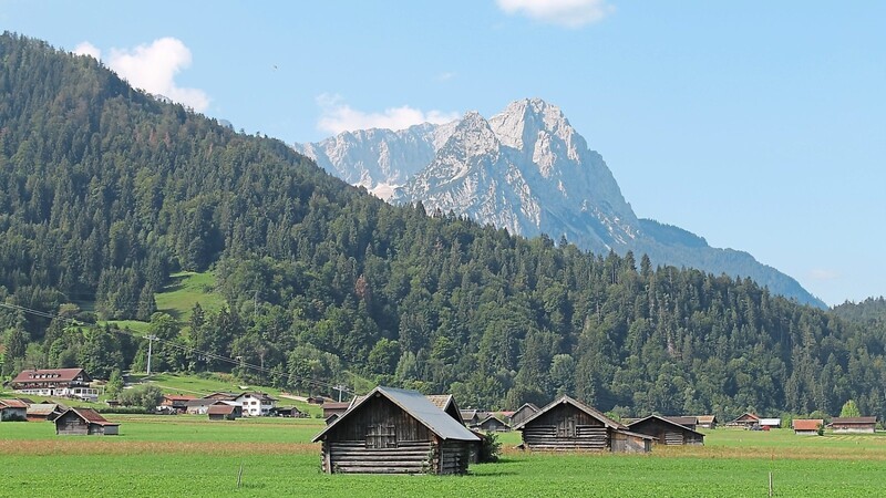 An sanftgrünen Wiesen am Rande von Garmisch-Partenkirchen sieht man in der Ferne das Ziel: die Zugspitze.