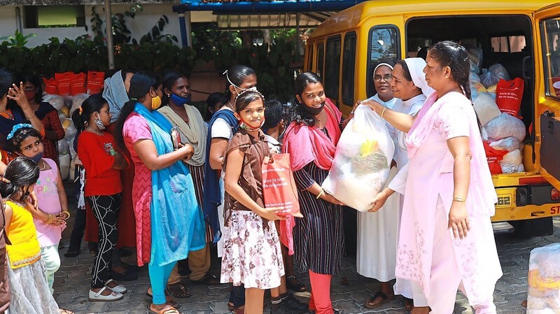 Schwester Kala verteilt mit einigen Lehrerinnen Lebensmittelsäcke an die Patenkinder und ihre Familien. Für das Foto haben sie den Mundschutz abgenommen, der sonst Pflicht ist.