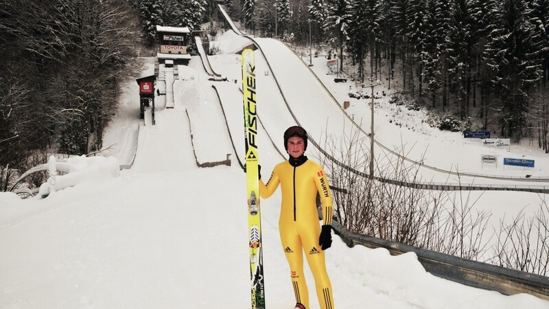 Die Ausrüstung zum Skispringen: lange Sprungski, ein enger Anzug, spezielle Sprungschuhe und ein Helm.