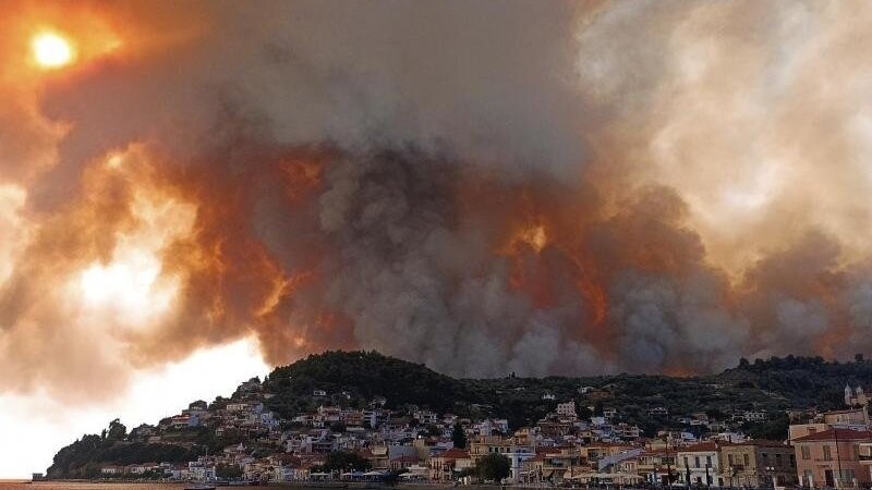 Rauch eines Waldbrandes steigt hinter einem Berghang in dem Ort Limni, auf der Halbinsel Euböa, etwa 160 Kilometer nördlich von Athen, auf.