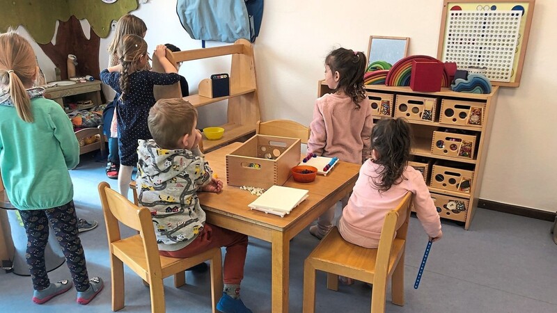 Kinder unterschiedlicher Nationen spielen in den Gruppenräumen miteinander.