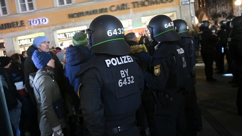 Polizisten stehen auf dem Marienplatz. Die Polizei in Bayern stellt sich in zahlreichen Kommunen auf unangemeldete "Spaziergänge" und Zusammenkünfte von Gegnern der staatlichen Corona-Maßnahmen ein.