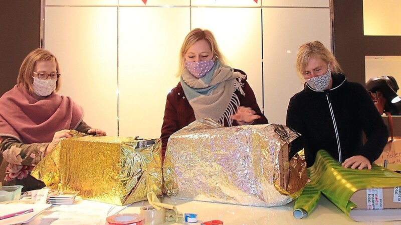 Das Organisationsteam Dagmar Reinecke, Julia Jung und Ina Zeller-Bleil verpackt die Weihnachtspäckchen für die großen Schaufenster.