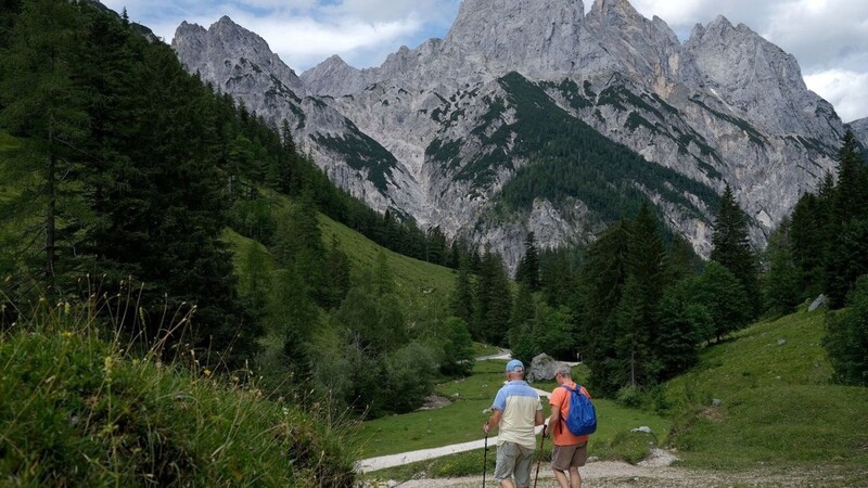 Wanderer gehen im Nationalpark Berchtesgaden auf einem Weg.