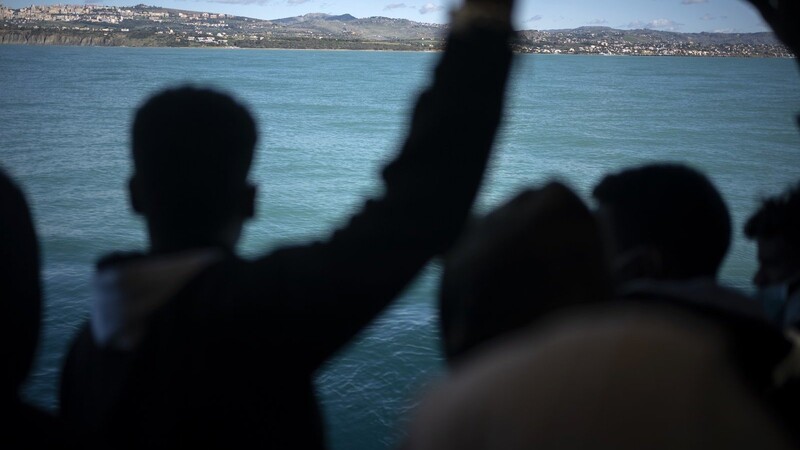 Migranten schauen von Bord des Schiffes auf die Küste Italiens. Straubing hat am 21. Dezember eine vierköpfige Familie im Rahmen der Aktion "Sicherer Hafen" aufgenommen.