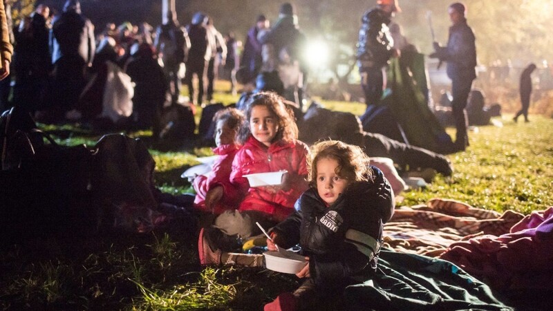 Flüchtlingskinder warten auf einer Wiese an der deutsch-österreichischen Grenze vor Wegscheid auf ihre Einreise nach Deutschland.