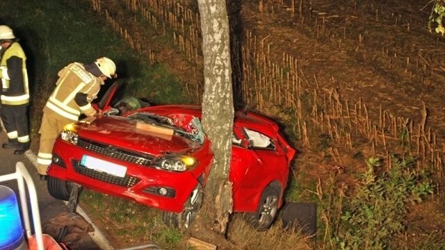 Der rote Opel des Unfallfahrers hat sich bei einem Verkehrsunfall auf der Kreisstraße SR 13 in Höhe Krottenholz regelrecht um einen Baum geschlungen.