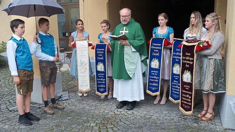 Pfarrer Siegmund Kastner segnete die Fahnenbänder, die Lisa Spagl, Milena Bücherl, Hannah Spagl, Sophia Spagl und Verena Alt (von rechts) an den Fahnen anbrachten.