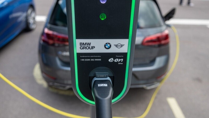 Ein Elektroauto lädt auf einem Parkplatz vor dem BMW-Werk.
