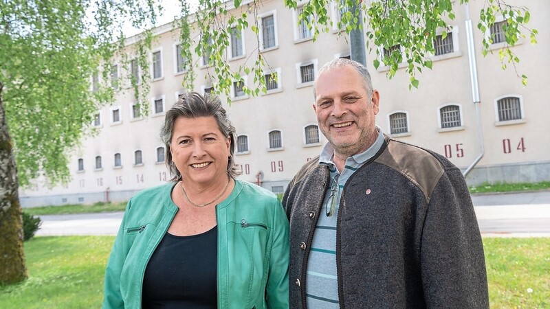 Laureen Koch und Gerhard Gruber, ehrenamtlichen Gefangenenbegleiter in Stadelheim, stehen im Innenhof vor einer Gefangenen-Unterkunft.