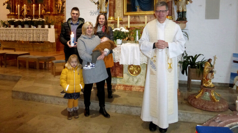 Täufling Hannes auf dem Arm seiner Patin mit seinen Eltern, Cousine Lisa und Pfarrer Johann Wutz.