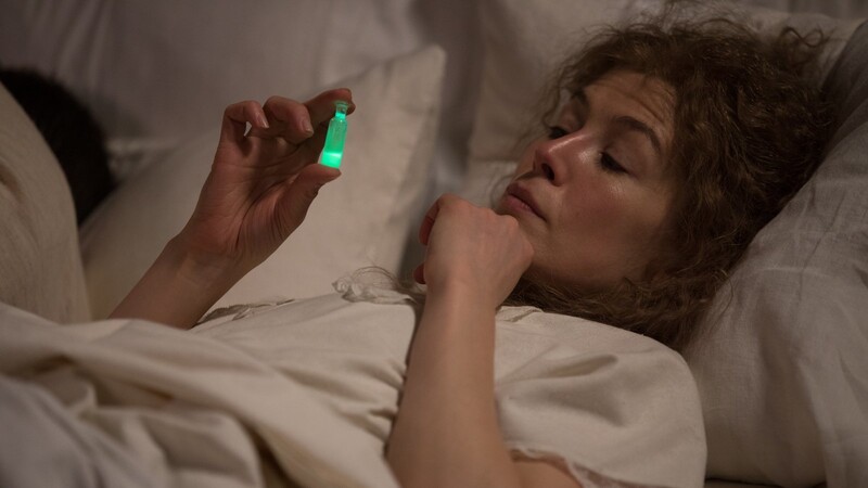 Marie Curie (Rosamund Pike) verwendet eine Radiumprobe als Nachtlicht neben ihrem Bett.