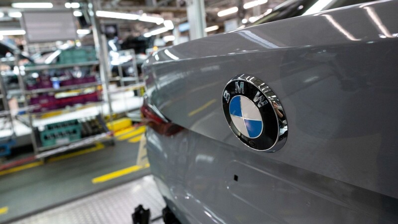 Verschiedene Modelle von BMW laufen in der Montage über ein Förderband.