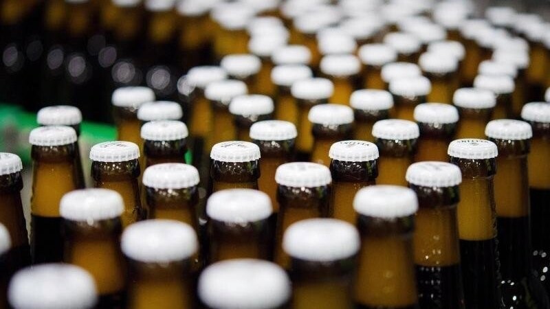 Bierflaschen mit Kronkorken laufen durch die Produktion.