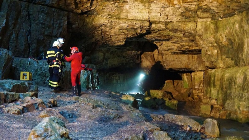 Einsatzkräfte der Bergwacht und Feuerwehrleute sind an der Falkensteiner Höhle im Einsatz. In der Falkensteiner Höhle in Baden-Württemberg sind zwei Menschen von ansteigenden Wassermassen überrascht und dadurch eingeschlossen worden.
