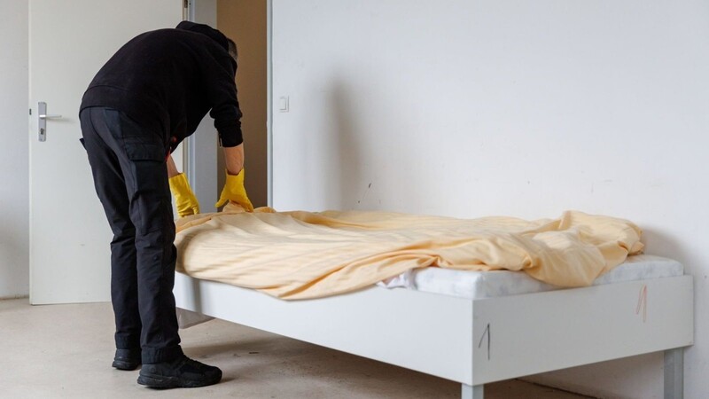 Ein Mitarbeiter der Notschlafstelle "Diana-Herberge" bereitet ein Zimmer vor.