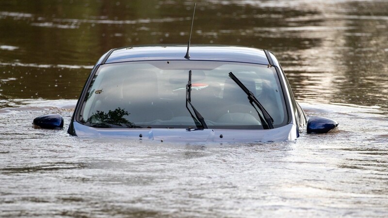 Ein Auto steht auf einem Parkplatz im Hochwasser, nachdem die Aisch über die Ufer getreten war.