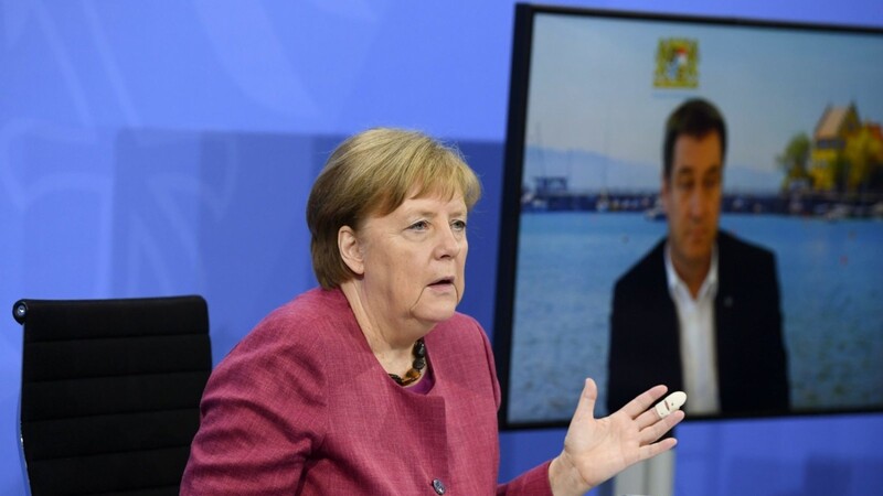 Bundeskanzlerin Angela Merkel (CDU) bei der Pressekonferenz nach dem Impfgipfel von Bund und Ländern. Im Hintergrund ist Bayerns Ministerpräsident Markus Söder (CSU) zu sehen, der per Video zugeschaltet wurde.