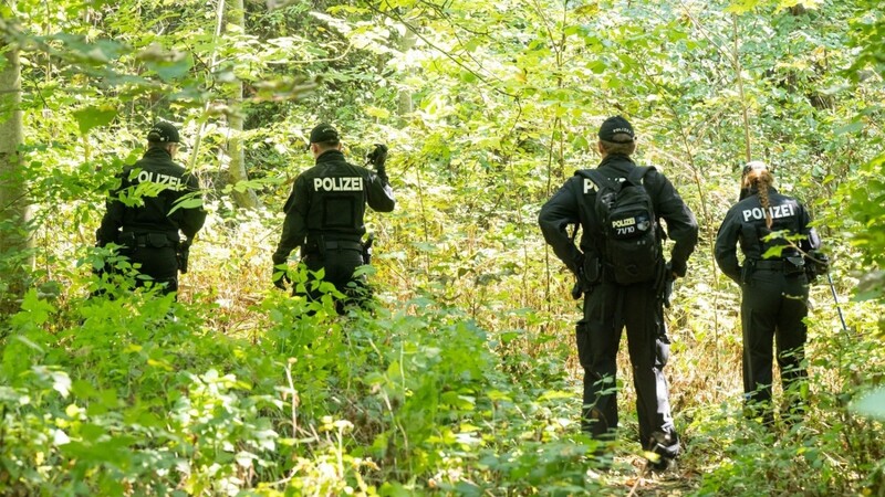 Polizisten durchsuchen ein Waldstück nach Spuren und Gegenständen, in dessen Nähe am 17. August eine weibliche Leiche in einem Auto entdeckt wurde.