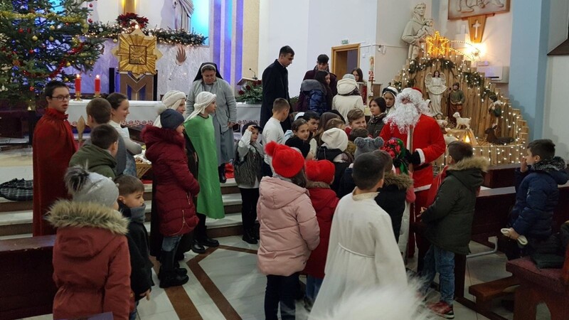 Der Nikolaus, Ordensschwester und Pfarrer verteilen die Geschenke vom Verein "Helfende Hände" an bedürftige Kinder.