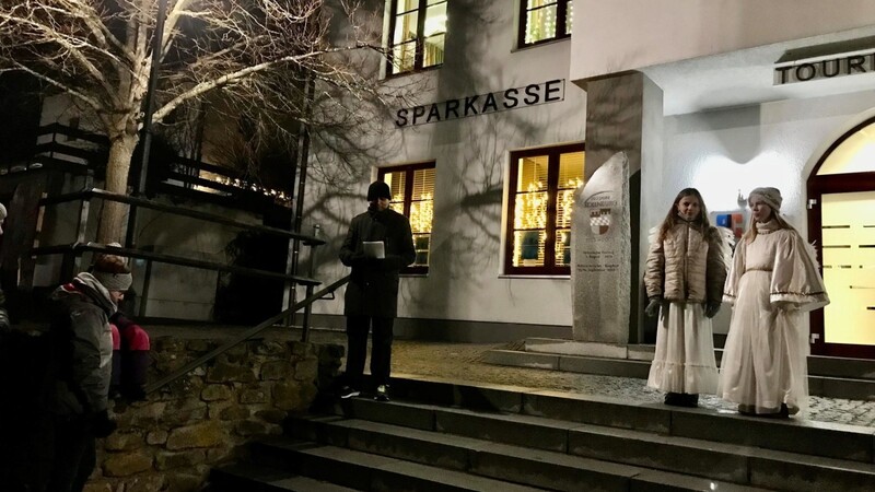 Pater Joseph begrüßt die Besucher des Lichterweges, besonders die beiden Christkindl Amelie Schlecht (li.) und Teresa Klingl, vor dem Rathaus in Kollnburg.