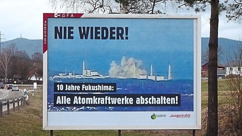 Mit Großplakaten erinnern Atomgegner an das schwere Reaktorunglück vor zehn Jahren.