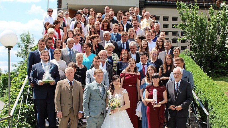 Das Brautpaar Isabella und Anton Engl zusammen mit ihren Verwandten und Freunden auf dem Treppenaufgang zur Lixenrieder Kirche.