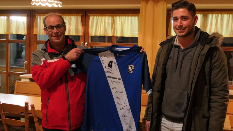 Vorsitzender Alfons Drexler (li.) übergibt dem Fan und Spieler des TSV Natternberg Jan Wagner das für 300 Euro ersteigerte Trikot.