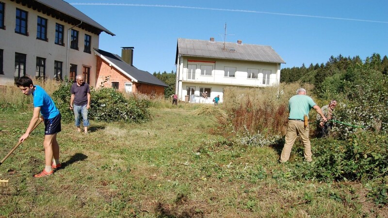 Mitglieder des Dorfvereins mit Vorsitzendem Josef Wanninger (2.v.li.) bei der Beseitigung des Wildwuchses am ehemaligen Schulhof