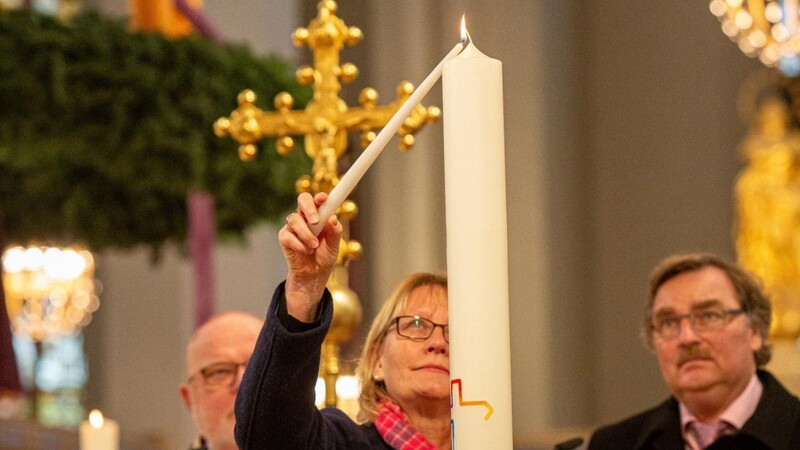 ZdK-Vizepräsidentin Karin Kortmann zündet im Beisein von Kardinal Reinhard Marx (l.) und Joachim Unterländer (r.), dem Vorsitzenden des Landeskomitees der Katholiken in Bayern, in München die Synodalkerze an.