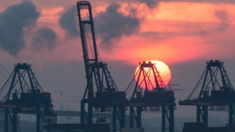 Sonnenuntergang hinter den Containerbrücken des HHLA Containerterminal Tollerort in Hamburg. Die Corona-Krise reißt tiefe Löcher in den Staatshaushalt.