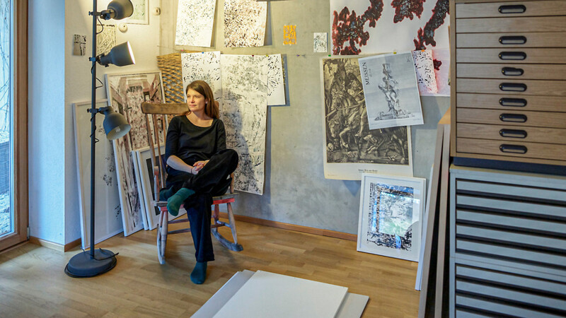 Stefanie Reiter vor einer Auswahl ihrer Werke, die mit Tinte, Tusche und in Aquarelltechnik entstehen.