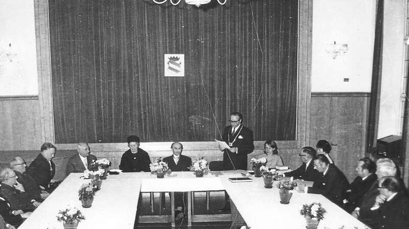 1973: Bürgermeister Hans Kick mit Amtskette hält im Rathaussaal nach der Verleihung des Bayerischen Poetentalers eine Lobrede auf Arthur Piechler, den großen Sohn der Stadt Landau. Neben dem Geehrten seine Frau Rosl, eine gebürtige Landauerin.