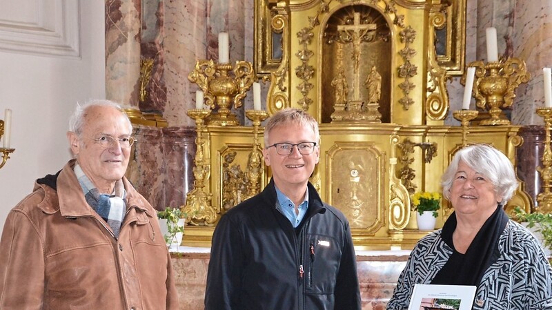 Dr. Albert Niedermayer (l.) und Christiane Jahrstorfer übergaben ein Buchexemplar an Pfarrer Adi Ortmeier in der Pfarrkirche Mariä Empfängnis. Der Geistliche gratulierte zum gelungenen Werk.