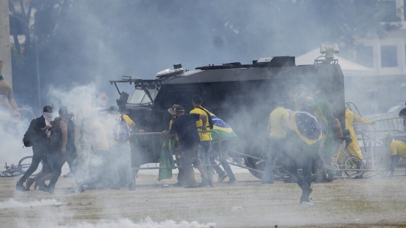 Anhänger des ehemaligen brasilianischen Präsidenten Bolsonaro greifen ein gepanzertes Polizeifahrzeug an.