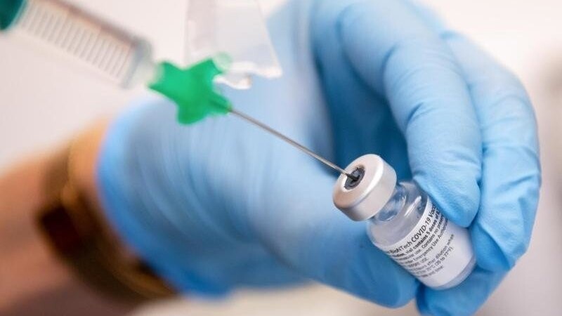 Eine Klinik-Mitarbeiterin zieht den Covid-19 Impfstoff von Biontech/Pfizer für eine Impfung auf eine Spritze. (Archivbild).