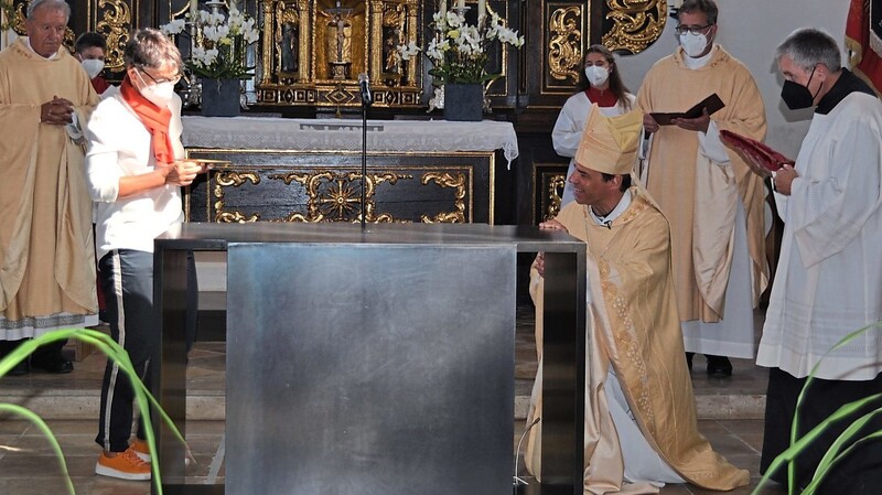 Bischof Dr. Stefan Oster schiebt die Reliquie vom heiligen Bruder Konrad von Parzham zusammen mit der Künstlerin Sabine Straub in den Altar.