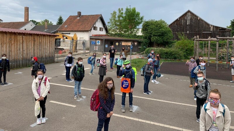 Auf dem Pausenhof der Sankt Peter Grundschule in Straubing hat jedes Kind seinen eigenen markierten Platz zugewiesen bekommen. Die Kinder kommen jeden Tag mit Mundschutz.