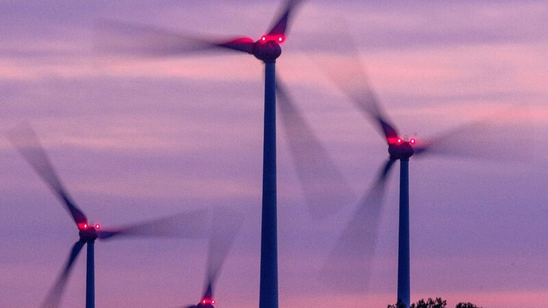 Windräder drehen sich nach Sonnenuntergang in einem mecklenburgischen Windpark.