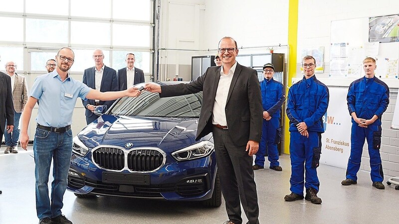 Schlüsselübergabe zwischen B.B.W.-Ausbilder Karl Bräumann (vorne links) und BMW-Personalleiter Reinhard Eberl mit B.B.W.-Vertretern und den angehenden Kfz-Mechatronikern.