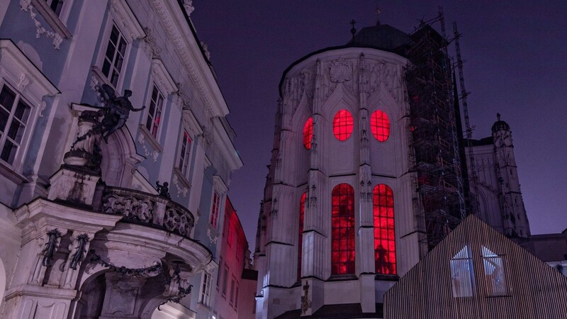 Der Innenraum des Doms St. Stephan in Passau wird am Freitagabend rot angestrahlt.